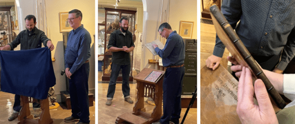 Three images, left Rob williams stands wearing a blue shirt and black trousers next to Dom from the repair shop who is holding a blue cloth over the top of a lecturn. Middle image is of Rob holding the repaired book in his hands and Dom standing nearby looking on with clasped hands. Right image is a pitcure of a black book spine in good restored condition. 
